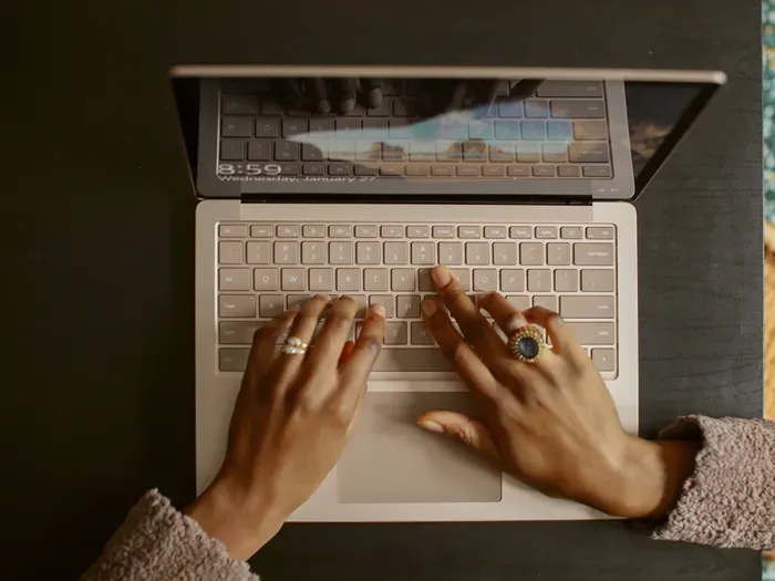 Hands typing on a laptop, a business owner adding a company to Local Biz Map for traffic and dofollow backlinks